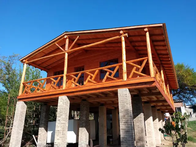 Cabaña de madera sobre estructura de labrillos